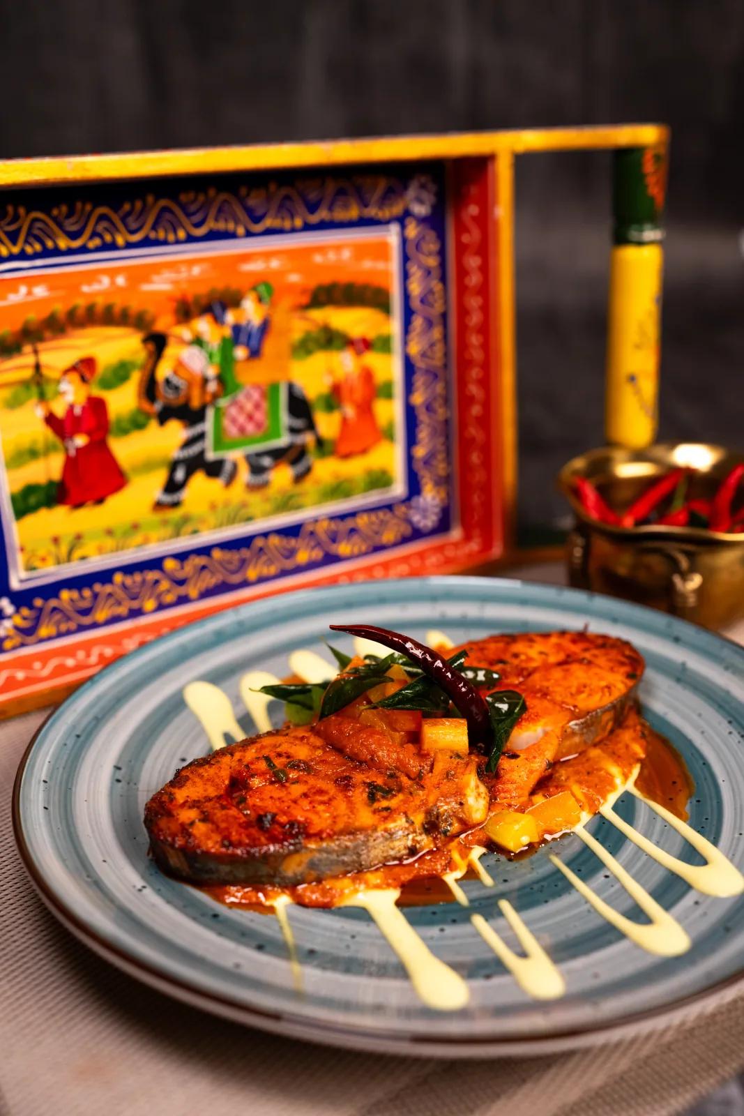 Grilled fish fillet on a ceramic plate against a painted backdrop, food photography by Rahul Chanda, food photographer in Dehradun